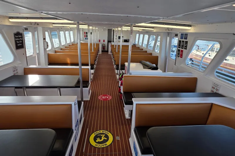 Ocean Thunder Yacht Photos Pics Interior of 1986 Gulf Craft Passenger boat with seating and safety signs.