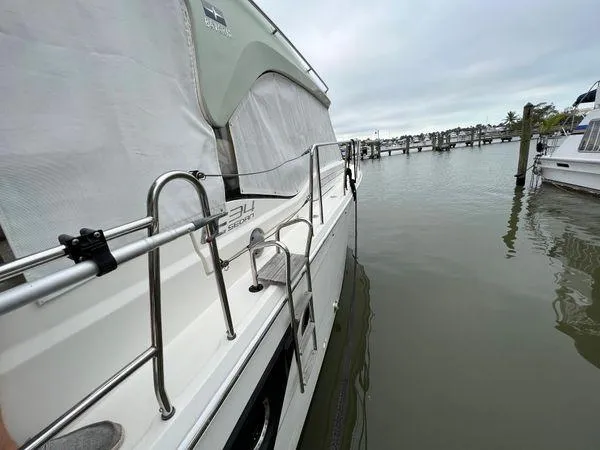  Yacht Photos Pics Bavaria E34 Sedan boat docked at marina, 2018 model, side view.