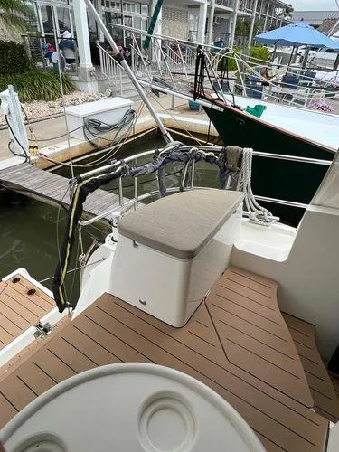  Yacht Photos Pics Boat docked at marina with wooden deck and cushioned seating, Bavaria E34 Sedan, 2018 model.