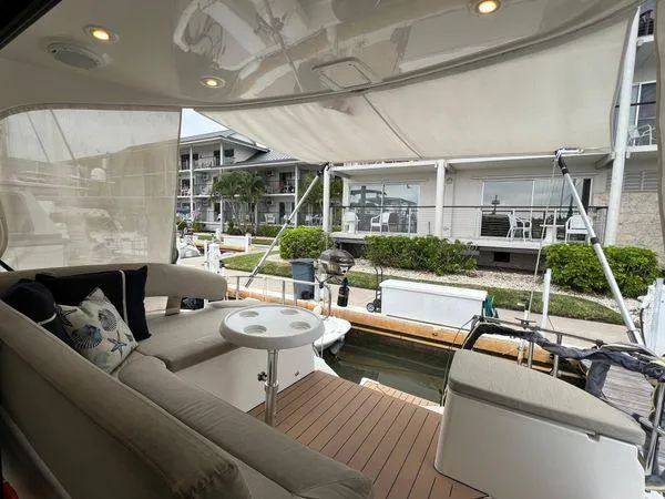  Yacht Photos Pics Luxury Bavaria E34 Sedan yacht deck with seating, table, and marina view, 2018 model.