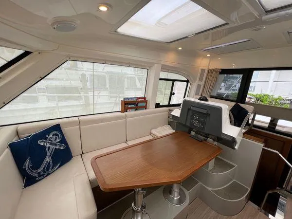  Yacht Photos Pics Luxurious Bavaria E34 Sedan 2018 yacht interior with plush seating and wooden table.