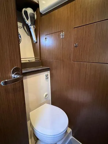 Yacht Photos Pics Compact bathroom in 2018 Bavaria E34 Sedan with wooden cabinetry and modern fixtures.