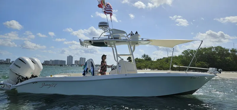  Yacht Photos Pics 2019 Young Boats 27 on water, sunny day, flags flying, city skyline in background.