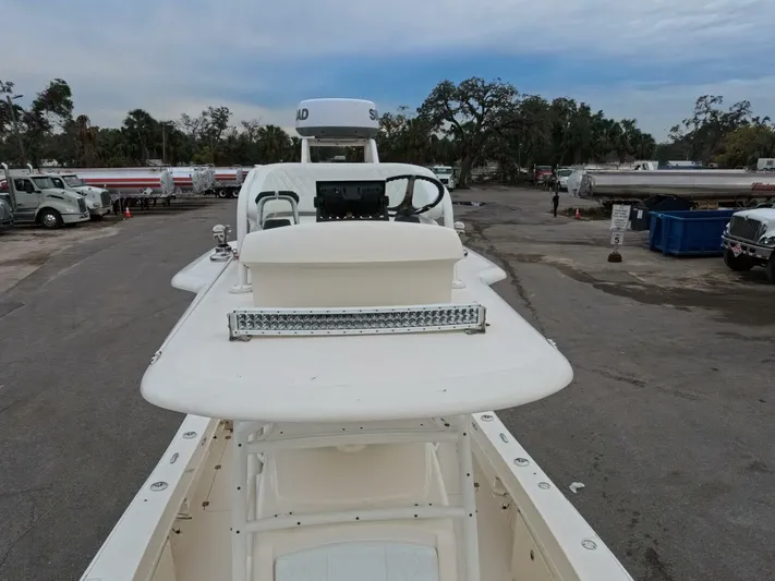  Yacht Photos Pics 2019 Young Boats 27 model, white deck view, parked outdoors with trees and trucks in background.