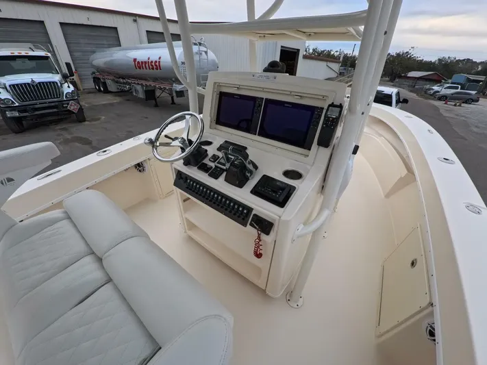  Yacht Photos Pics 2019 Young Boats 27 console with dual screens and steering wheel in a marina setting.