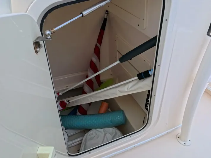  Yacht Photos Pics Storage compartment on a 2019 Young Boats 27, containing boating accessories and equipment.