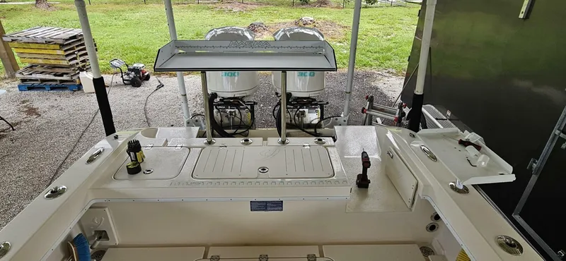  Yacht Photos Pics 2019 Young Boats 27 with dual engines, parked under a shelter on gravel.