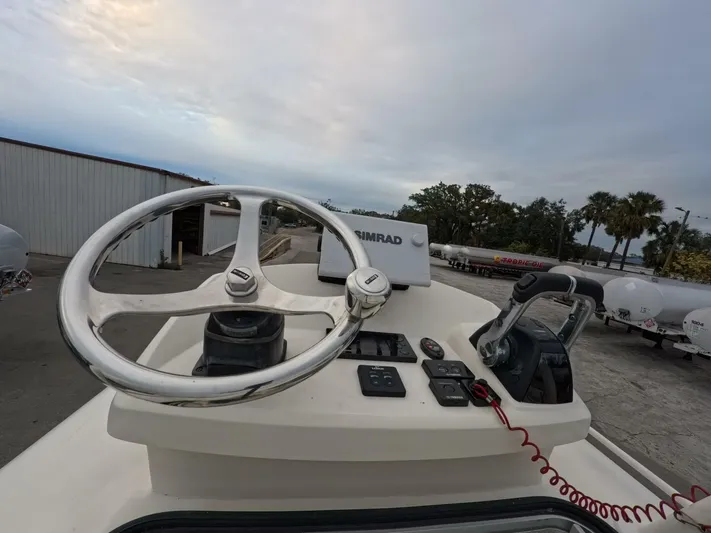  Yacht Photos Pics 2019 Young Boats 27 helm with steering wheel and controls, docked outdoors.