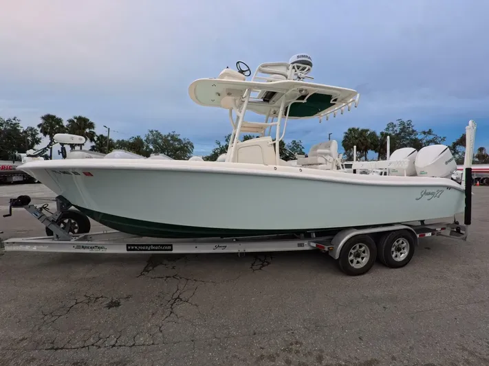  Yacht Photos Pics 2019 Young Boats 27 on trailer, parked outdoors, with trees in the background.