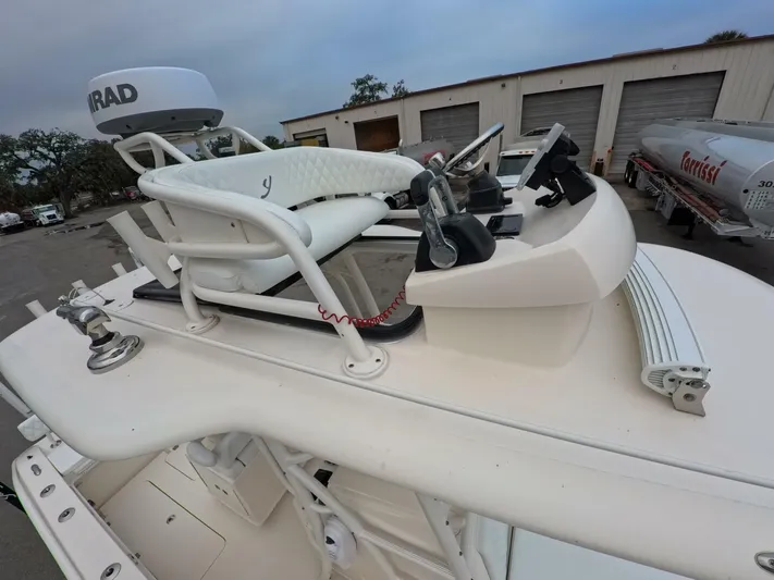  Yacht Photos Pics 2019 Young Boats 27 helm with controls and seating, docked near storage units.