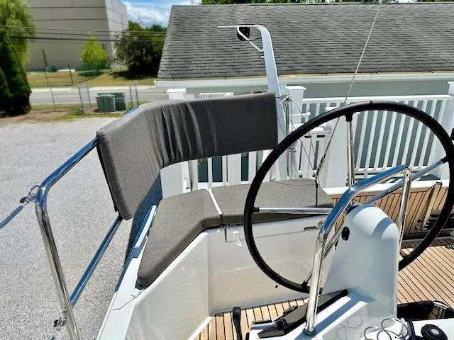 Jessy Yacht Photos Pics 2023 Jeanneau Sun Odyssey 490 helm station with cushioned seating and steering wheel.