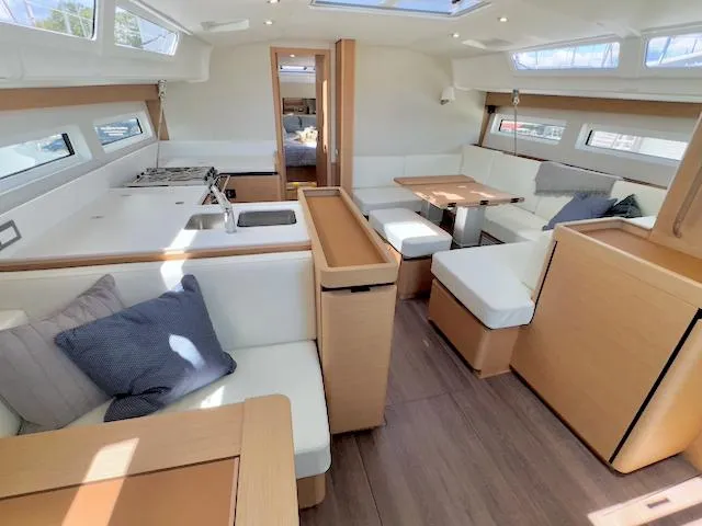 Jessy Yacht Photos Pics Modern interior of 2023 Jeanneau Sun Odyssey 490 yacht with spacious seating and kitchen area.