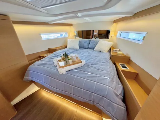 Jessy Yacht Photos Pics Luxurious cabin interior of 2023 Jeanneau Sun Odyssey 490 yacht with cozy bedding.