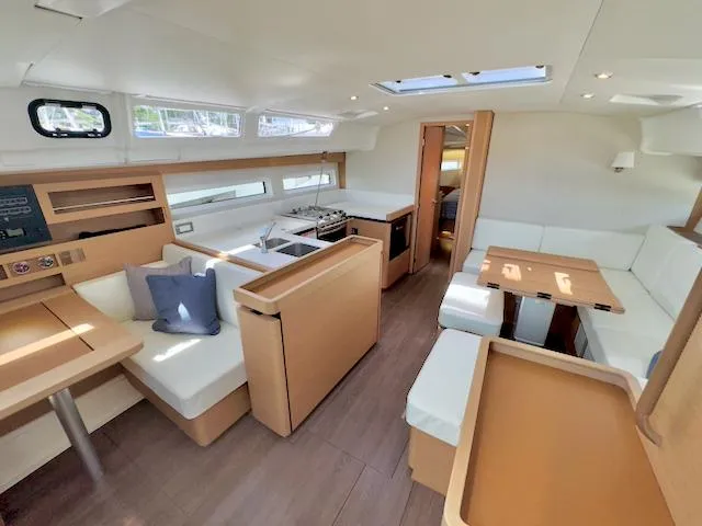 Jessy Yacht Photos Pics Interior of 2023 Jeanneau Sun Odyssey 490 yacht, featuring modern seating and dining area.