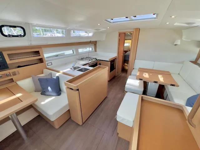 Jessy Yacht Photos Pics Luxurious interior of 2023 Jeanneau Sun Odyssey 490 yacht with modern kitchen and seating area.