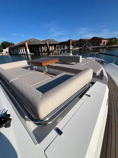  Yacht Photos Pics 2025 Astondoa AS 8 yacht with luxurious deck seating, docked near waterfront buildings.