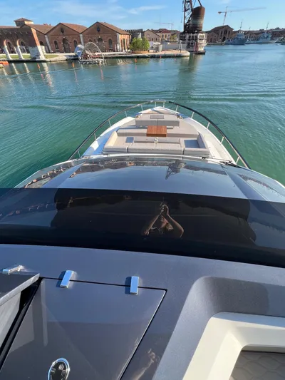  Yacht Photos Pics 2025 Astondoa AS 8 yacht cruising in a serene harbor with historic buildings.