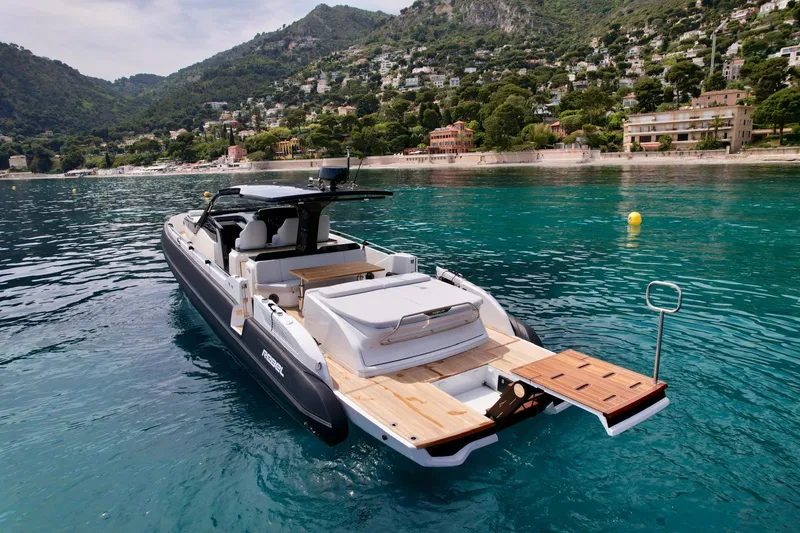 Rebel 47 Yacht Photos Pics 2025 SACS Rebel 47 yacht on clear water near scenic coastline.