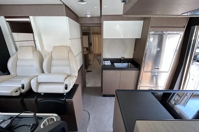  Yacht Photos Pics Interior of 2022 Azimut Magellano 66 yacht with modern seating and kitchenette.