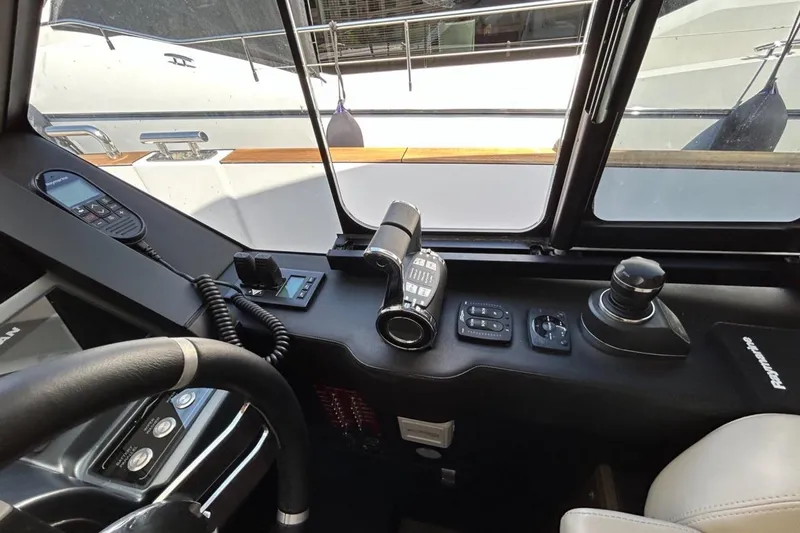  Yacht Photos Pics Cockpit controls of 2022 Azimut Magellano 66 yacht, featuring steering wheel and navigation instruments.