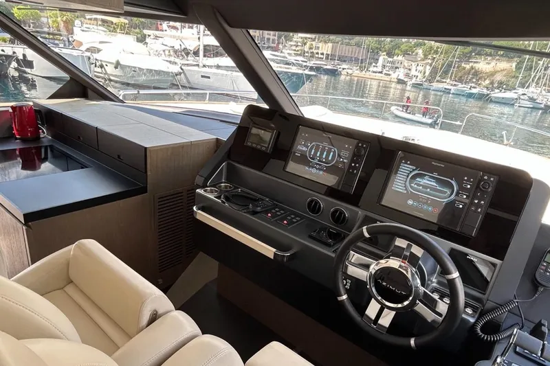  Yacht Photos Pics Luxurious 2022 Azimut Magellano 66 yacht helm with modern navigation displays and leather seating.