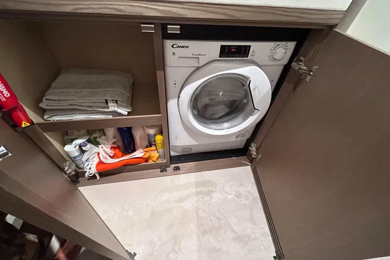  Yacht Photos Pics Laundry area on 2022 Azimut Magellano 66 yacht with washer and storage shelves.