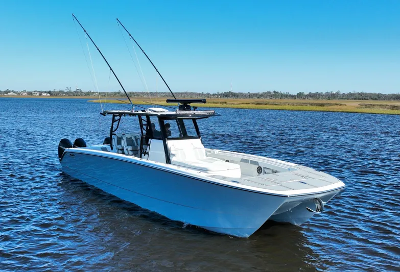  Yacht Photos Pics 2022 Invincible 40 Catamaran on calm water, featuring sleek design and fishing rods.