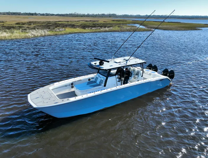  Yacht Photos Pics Invincible 40 Catamaran 2022 cruising on calm waters, showcasing sleek design and fishing rods.