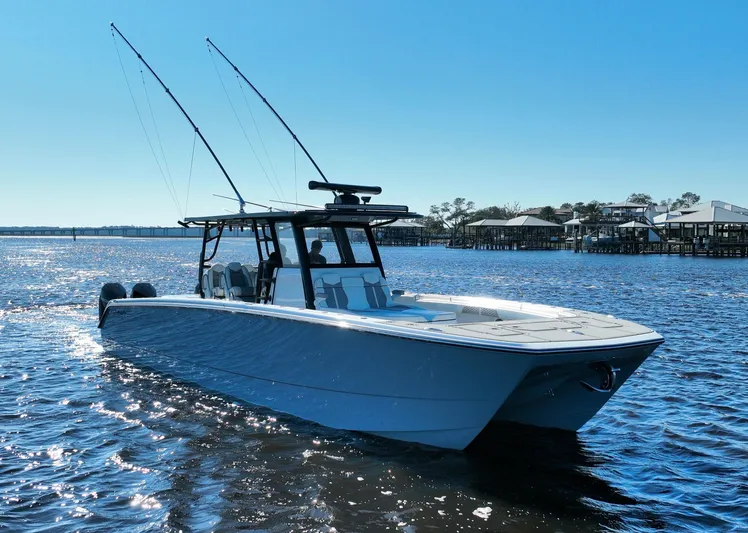  Yacht Photos Pics 2022 Invincible 40 Catamaran on water, clear sky, fishing rods visible.