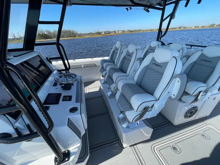  Yacht Photos Pics Luxurious seating on 2022 Invincible 40 Catamaran, featuring modern helm and scenic water view.