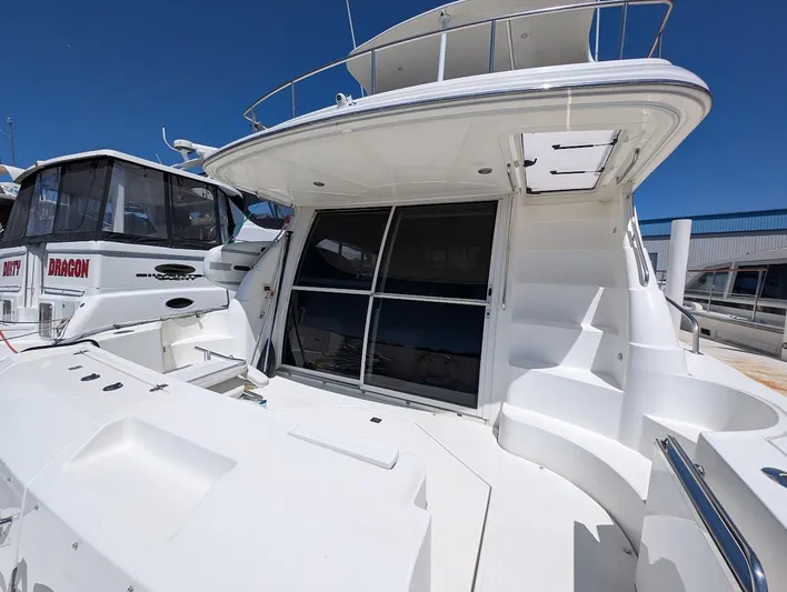 The Last Run Yacht Photos Pics 2003 Cruisers Yachts 5000 Sport Sedan docked, showcasing sleek design and spacious deck.