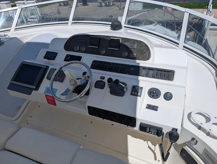 The Last Run Yacht Photos Pics 2003 Cruisers Yachts 5000 Sport Sedan helm with steering wheel and navigation controls.