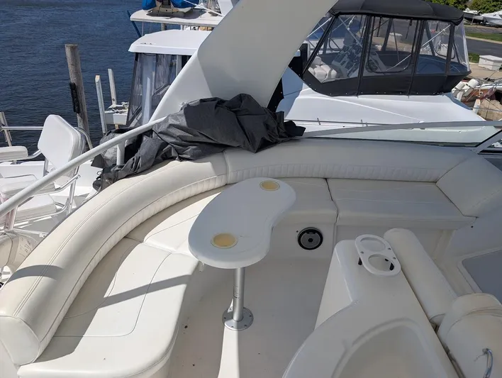 The Last Run Yacht Photos Pics 2003 Cruisers Yachts 5000 Sport Sedan with white seating and table on deck.