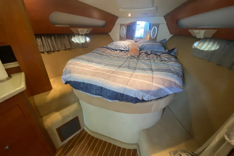  Yacht Photos Pics 2008 Rinker 350 Express Cruiser cabin with cozy bed and striped bedding.
