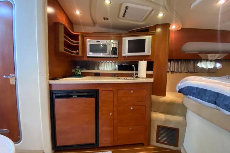  Yacht Photos Pics 2008 Rinker 350 Express Cruiser interior with kitchenette, microwave, and cozy sleeping area.