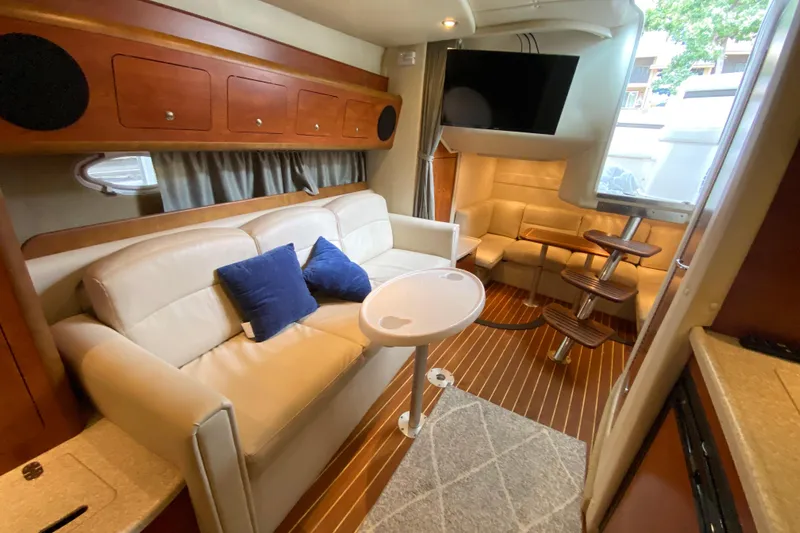  Yacht Photos Pics 2008 Rinker 350 Express Cruiser interior with beige seating, wooden accents, and a mounted TV.