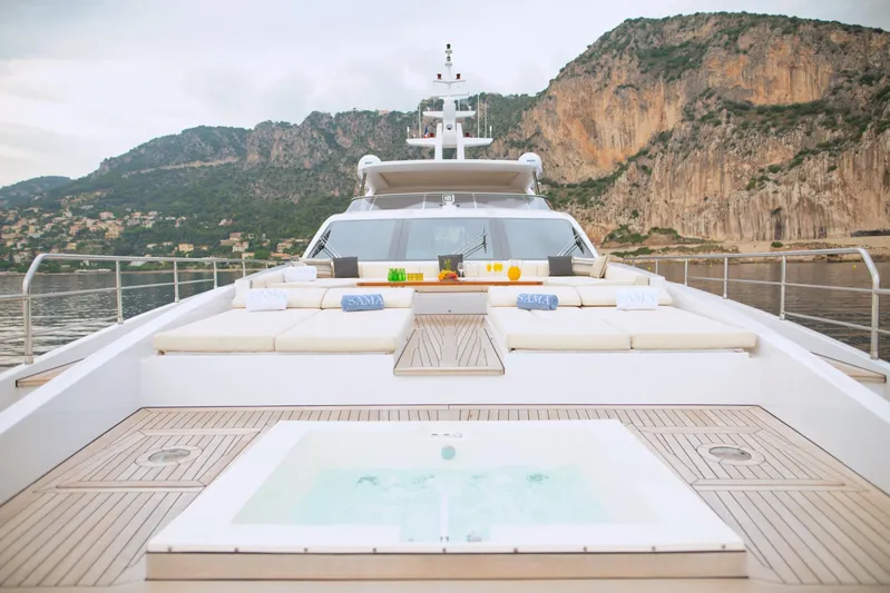 Sama Yacht Photos Pics Luxurious Azimut Grande 35 Metri yacht deck with jacuzzi, 2017 model, scenic coastal backdrop.