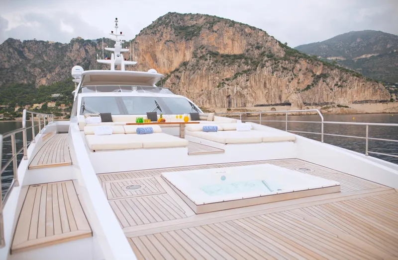 Sama Yacht Photos Pics Luxurious Azimut Grande 35 Metri yacht deck with jacuzzi, 2017 model, scenic coastal backdrop.