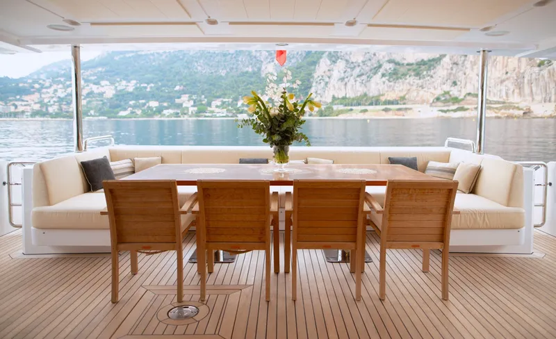 Sama Yacht Photos Pics Luxurious Azimut Grande 35 Metri yacht deck with dining area, 2017 model, scenic coastal view.