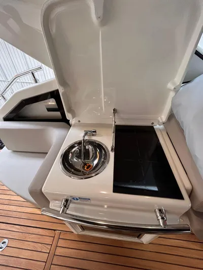  Yacht Photos Pics 2023 Cranchi M 44 HT yacht kitchenette with stove and sink on teak deck.