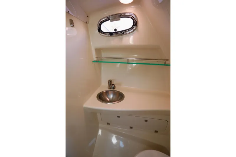 Libres Y Lokos Yacht Photos Pics 2016 Boston Whaler 285 Conquest cabin interior with sink and porthole window.