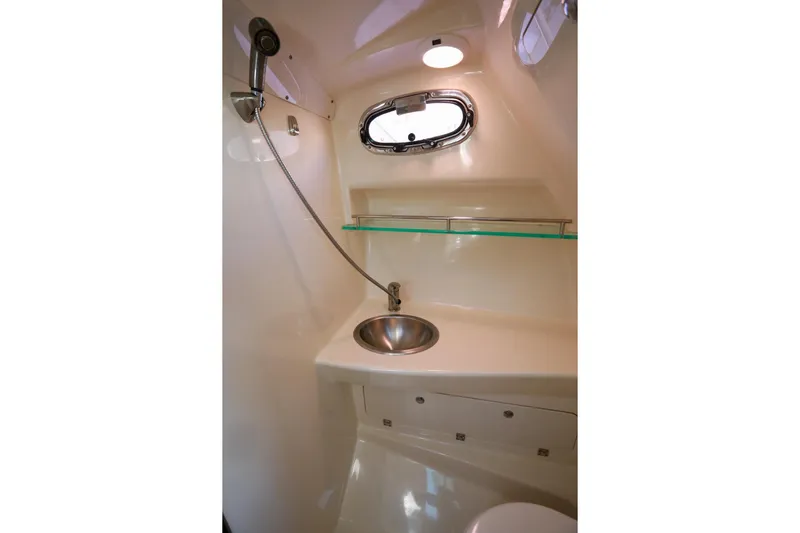 Libres Y Lokos Yacht Photos Pics 2016 Boston Whaler 285 Conquest bathroom with sink, shower, and porthole window.
