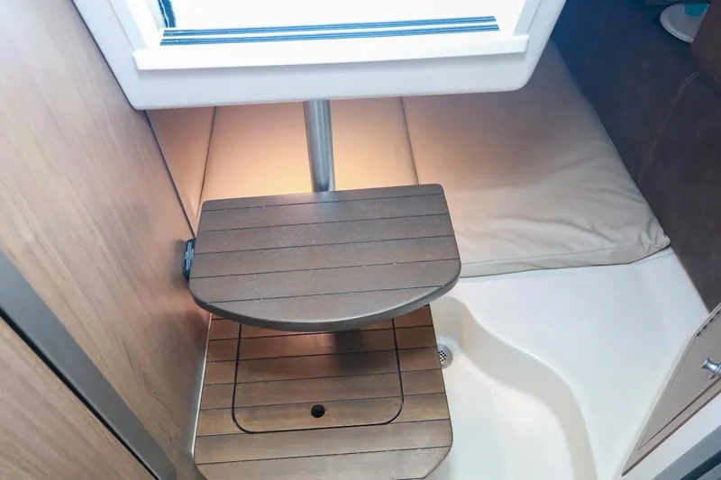 Libres Y Lokos Yacht Photos Pics 2016 Boston Whaler 285 Conquest cabin interior with wooden steps and cushioned seating.