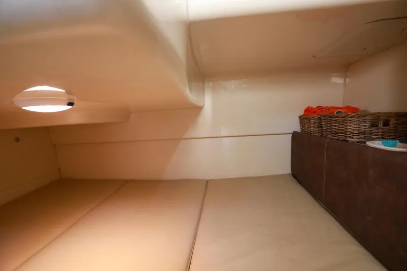 Libres Y Lokos Yacht Photos Pics 2016 Boston Whaler 285 Conquest cabin interior with cozy bedding and storage baskets.