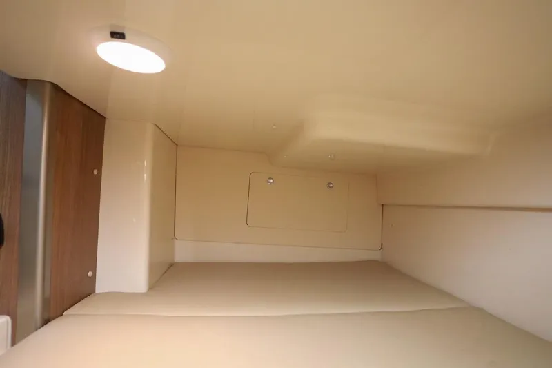 Libres Y Lokos Yacht Photos Pics 2016 Boston Whaler 285 Conquest cabin interior with soft lighting and beige upholstery.