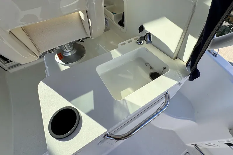 Libres Y Lokos Yacht Photos Pics 2016 Boston Whaler 285 Conquest boat sink and seating area detail.