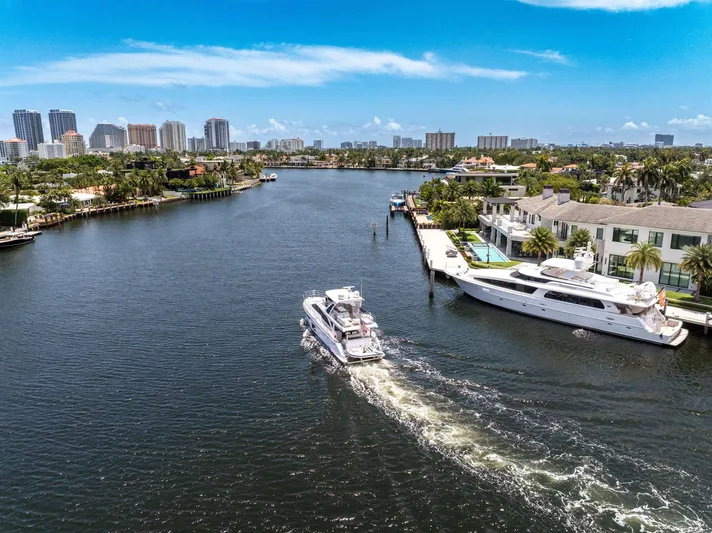  Yacht Photos Pics Azimut Fly 60 yacht cruising in a scenic waterfront cityscape, 2022 model.