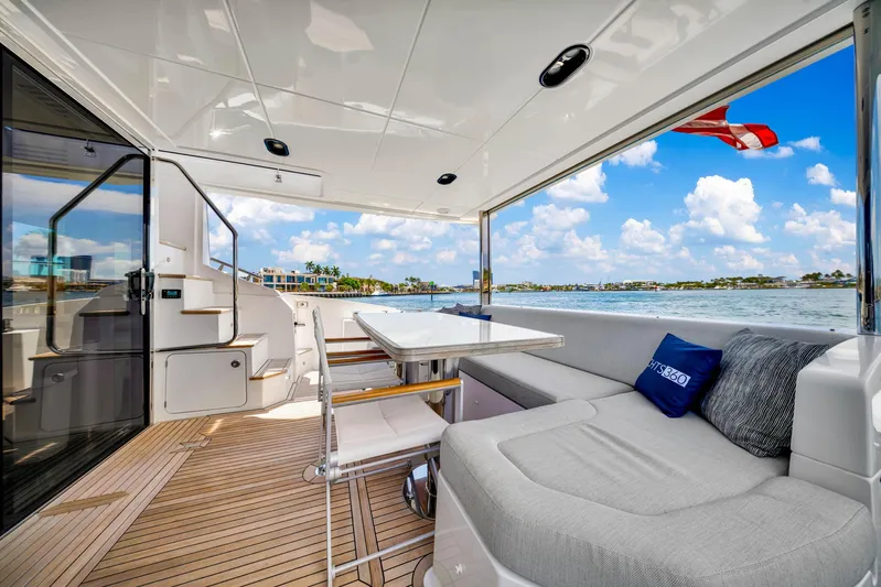  Yacht Photos Pics Luxurious 2022 Azimut Fly 60 yacht deck with seating, table, and scenic water view.