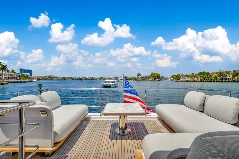  Yacht Photos Pics Azimut Fly 60 yacht deck with seating, American flag, and scenic water view, 2022 model.
