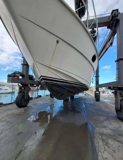  Yacht Photos Pics 1998 Viking Sports Cruiser on a lift at a marina, showcasing its hull design.